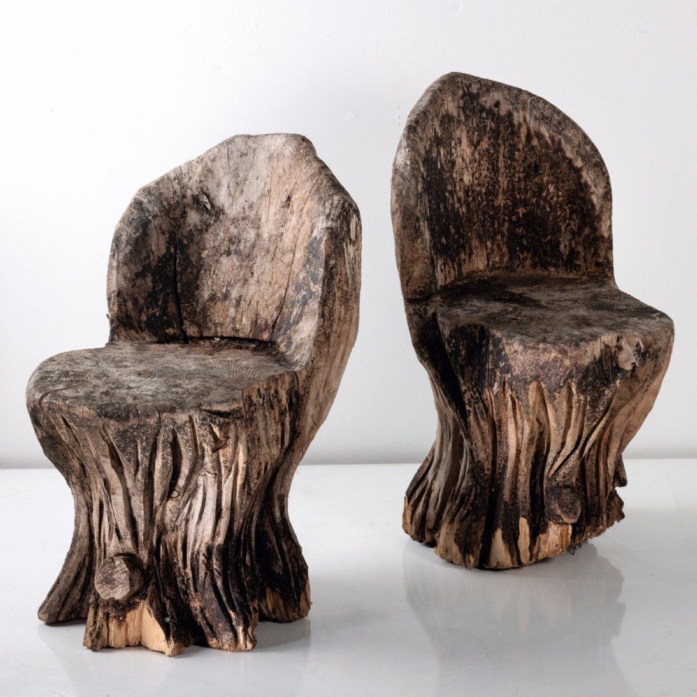 A pair of hand-carved dugout garden seats crafted from solid tree trunks with weathered timber surfaces. View V
