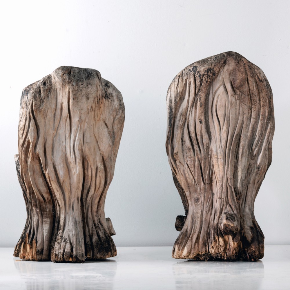A pair of hand-carved dugout garden seats crafted from solid tree trunks with weathered timber surfaces. View VI