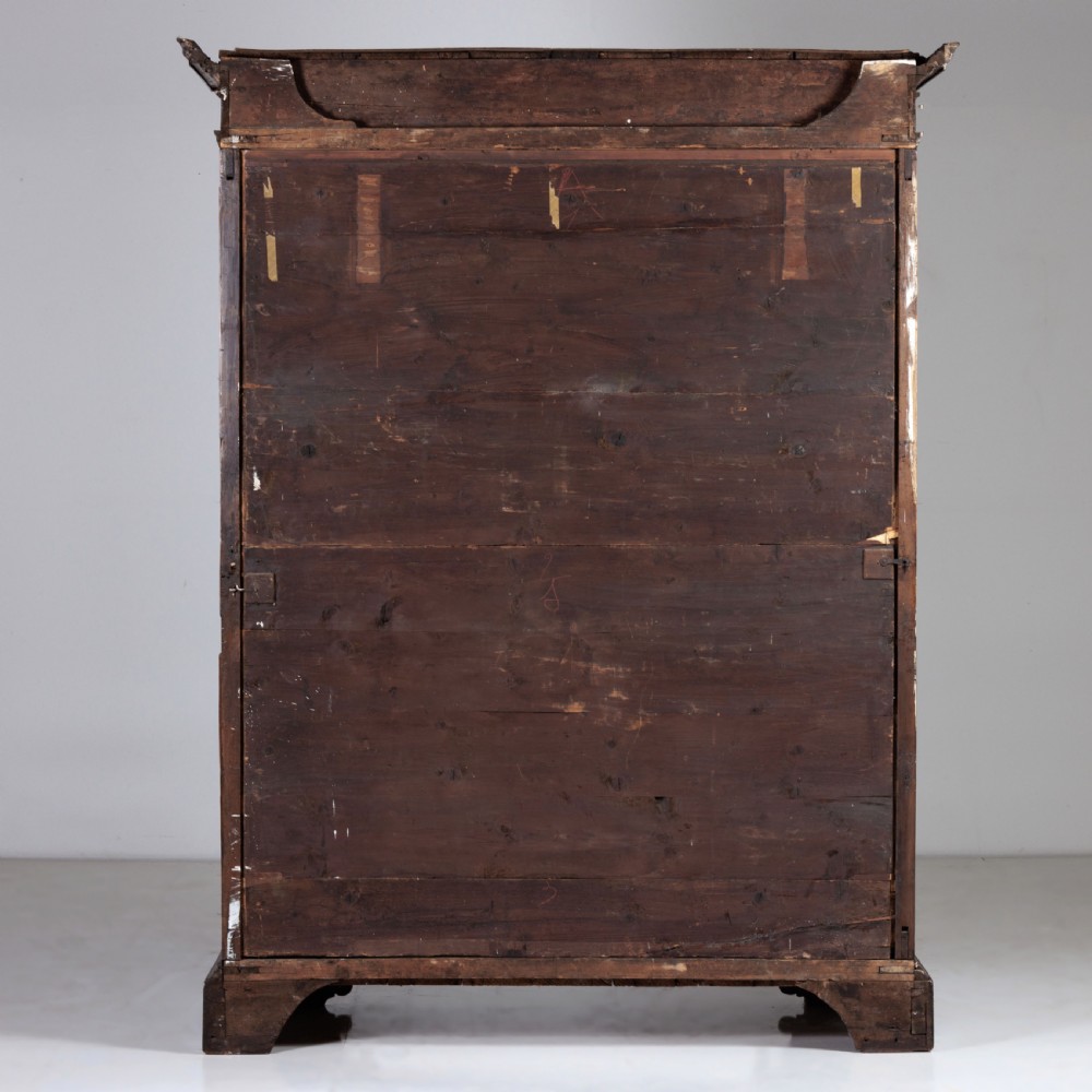 A large seventeenth-century Italian walnut cabinet featuring two tall panelled doors with carved geometric star relief motifs, framed by moulded side pilasters and resting on bracket feet. View XII