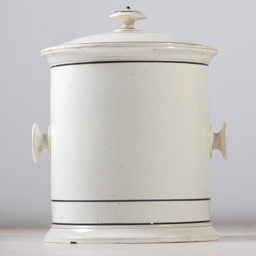 A cylindrical white ceramic jar with a fitted knopped lid, small side handles, and black Gothic script reading Prince Regent. View V