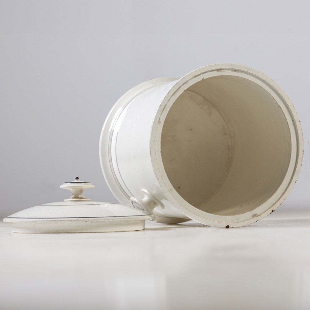 A cylindrical white ceramic jar with a fitted knopped lid, small side handles, and black Gothic script reading Prince Regent. View VI