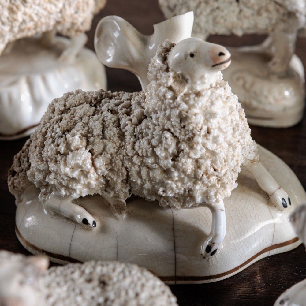 A collection of eight antique 19th-century cream and white ceramic Staffordshire sheep and lamb figurines with textured shredded-clay fleece. View III