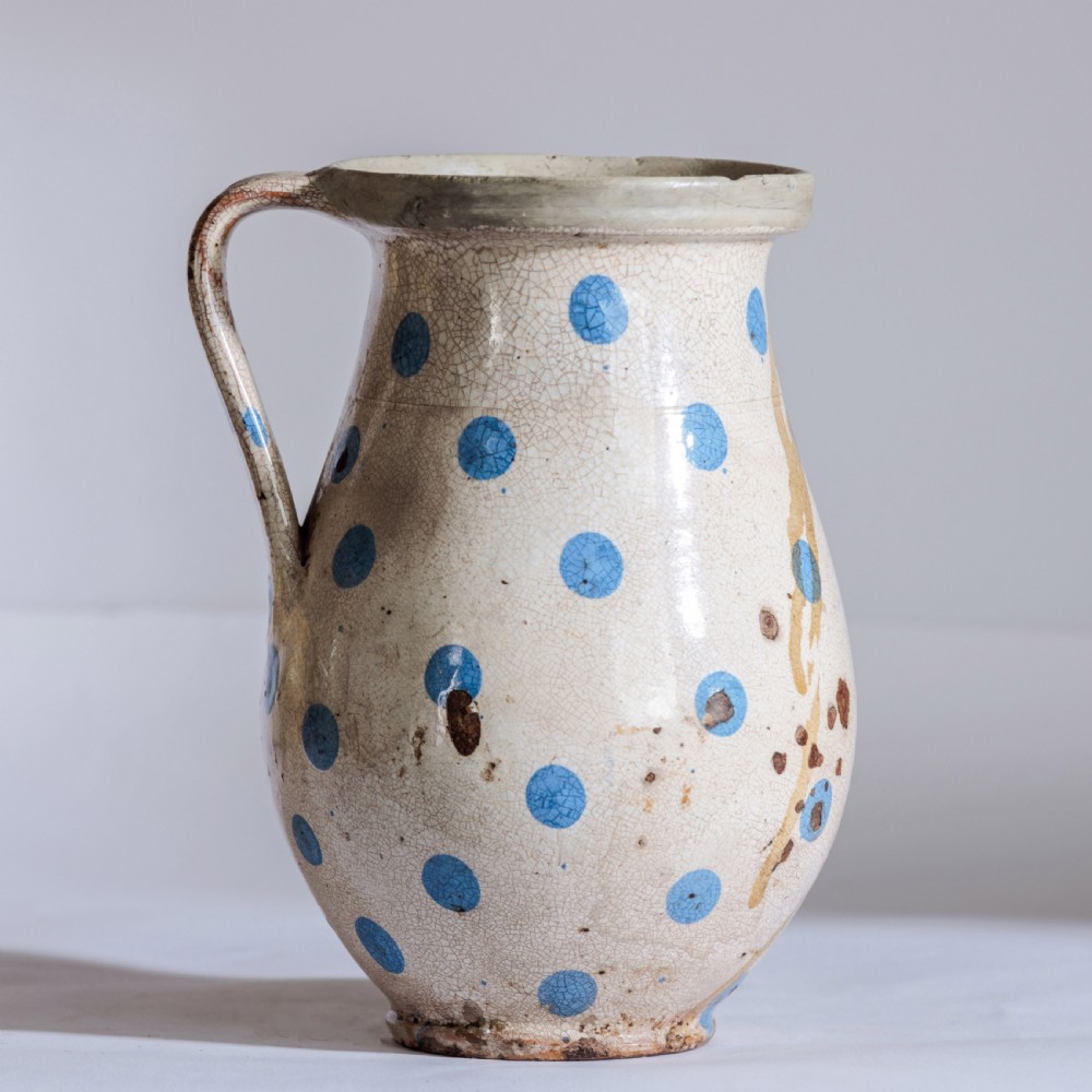 A collection of twelve 19th-century earthenware jugs in varying sizes and colours, each decorated with hand-painted spot and polka dot motifs. View III