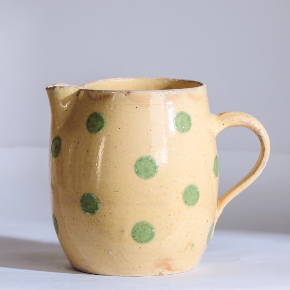 A collection of twelve 19th-century earthenware jugs in varying sizes and colours, each decorated with hand-painted spot and polka dot motifs. View IV