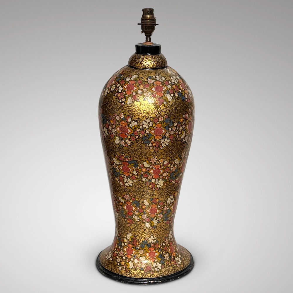 A tall baluster-shaped Kashmiri table lamp decorated with dense hand-painted gold and pink floral motifs.