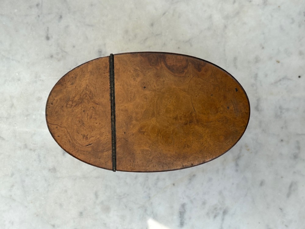 A pair of antique Georgian oval tea caddies made from burr walnut wood with flat lids. View V