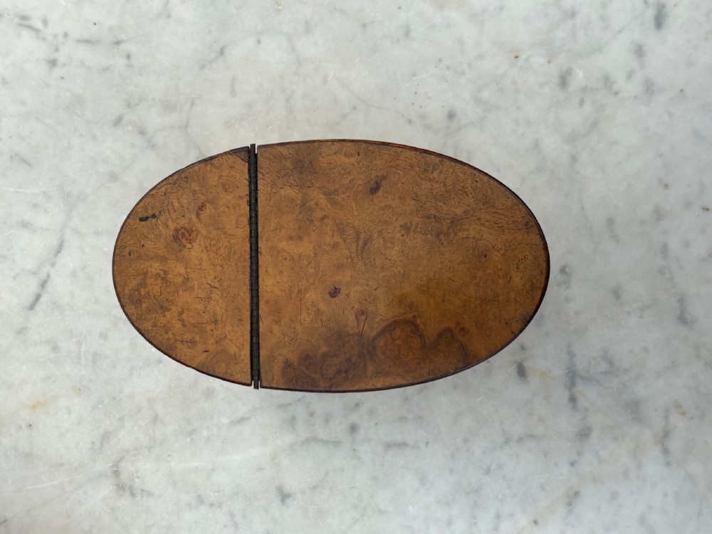 A pair of antique Georgian oval tea caddies made from burr walnut wood with flat lids. View VI