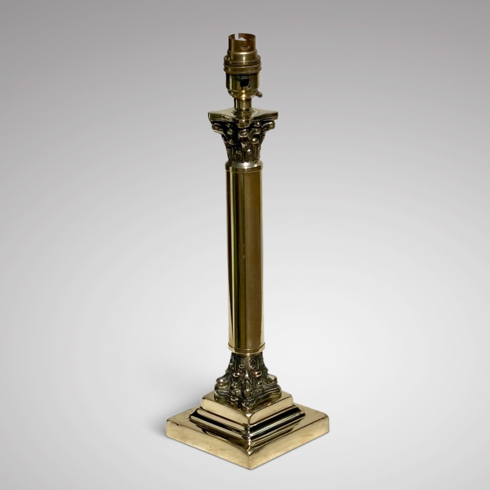 An Edwardian brass table lamp featuring a Corinthian column stem and a pleated cream lampshade decorated with a floral motif. View II