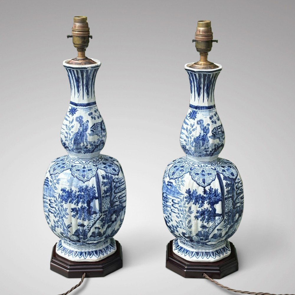 A pair of 19th-century blue and white Delftware ceramic table lamps with hand-painted figurative scenes, mounted on dark timber bases with cream scalloped shades. View III