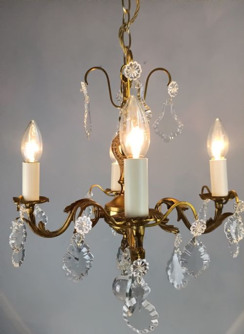 fig 1. A French gilded brass four-light chandelier adorned with faceted crystal drops and a central crystal sphere finial.