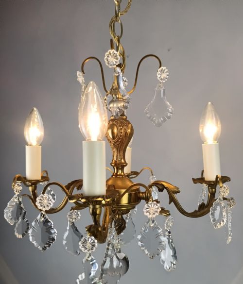 fig 2. A French gilded brass four-light chandelier adorned with faceted crystal drops and a central crystal sphere finial.