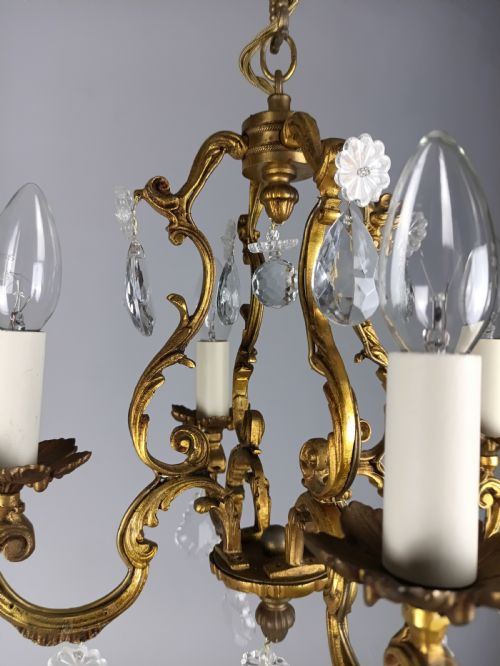 fig 1. A French Rococo style three-light gilded brass chandelier decorated with suspended cut crystal drops and candle-effect light holders.