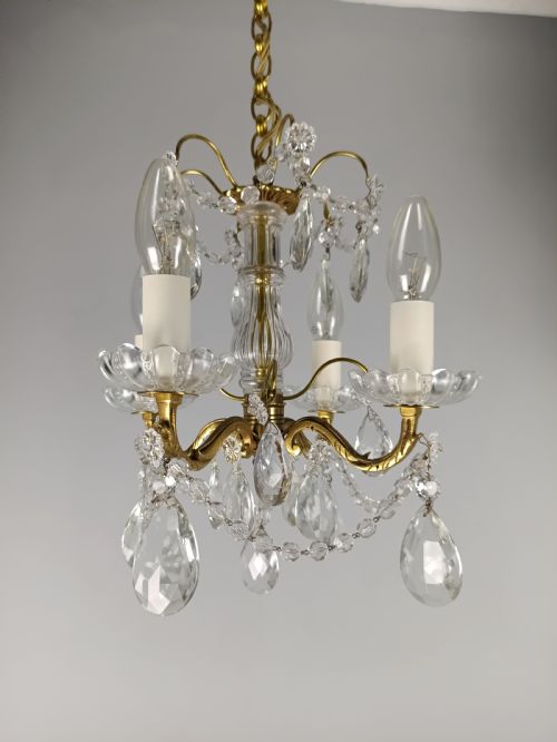 fig 2. A small French brass four-light chandelier adorned with clear cut-crystal droplets, faceted glass swags, and scalloped glass drip pans.