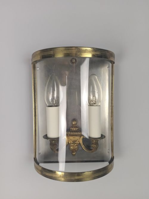fig 3. A pair of French gilt brass half-lantern wall lights featuring curved clear glass panels and twin candle-style sockets.