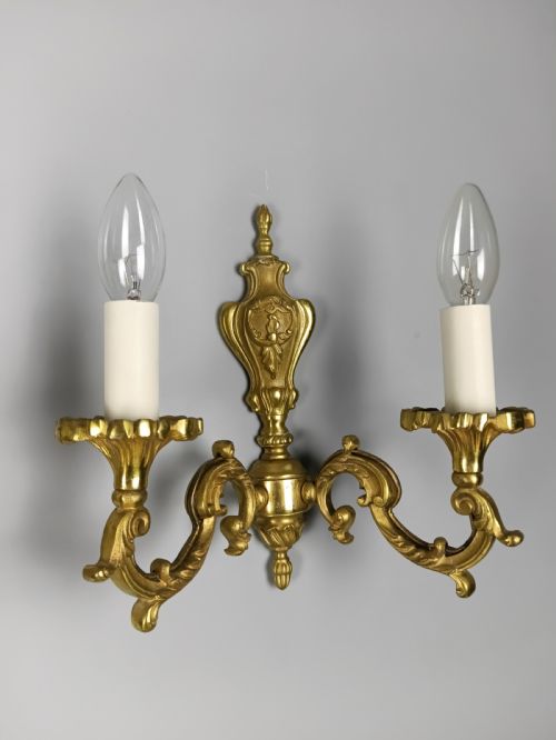 fig 2. A pair of antique French gilded brass wall sconces with twin scrolling arms, central backplates, and candle-style bulb holders.