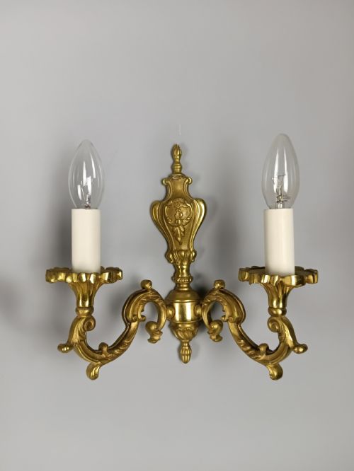 fig 3. A pair of antique French gilded brass wall sconces with twin scrolling arms, central backplates, and candle-style bulb holders.