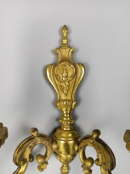 fig 5. A pair of antique French gilded brass wall sconces with twin scrolling arms, central backplates, and candle-style bulb holders.
