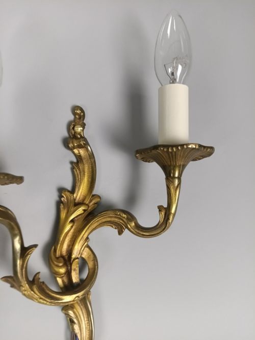 fig 6. A set of three French gilded bronze twin-arm wall lights with ornate foliage scrolling and candle-style sockets.