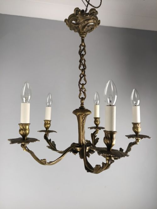 fig 1. A five-arm dark bronze chandelier with cast acanthus leaf arms, white candle sleeves, and a matching hanging chain with ceiling rose.