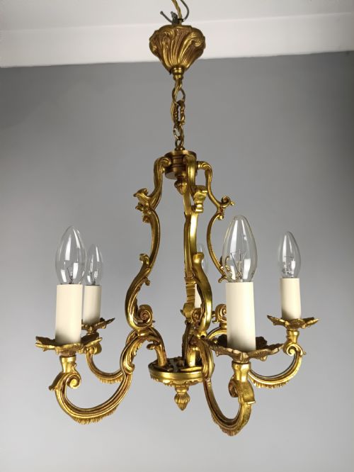 fig 1. A French five-light gilt bronze birdcage chandelier featuring open rococo scrollwork arms, leafy candle drip pans, and a central open frame suspended by a chain.