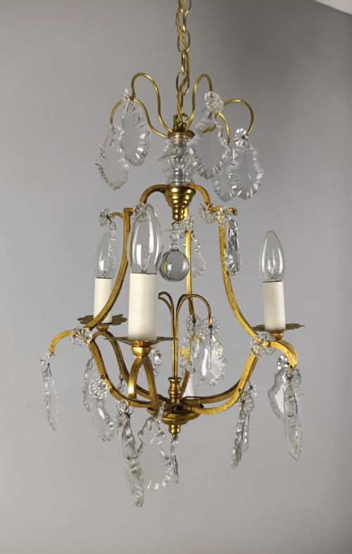 fig 2. A French gilded metal three-arm birdcage chandelier with hanging clear crystal droplets and glass rosette accents.