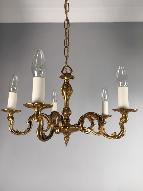fig 1. A French five-light gilt bronze chandelier featuring scrolling Rococo arms, candle-style bulb holders, and a central chased stem.