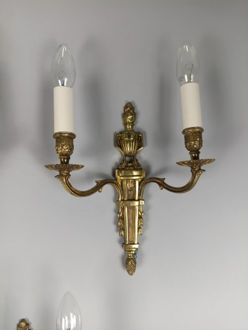 fig 3. Set of three French Louis XVI style twin-arm wall lights in gilded metal with urn backplates and fluted shafts.