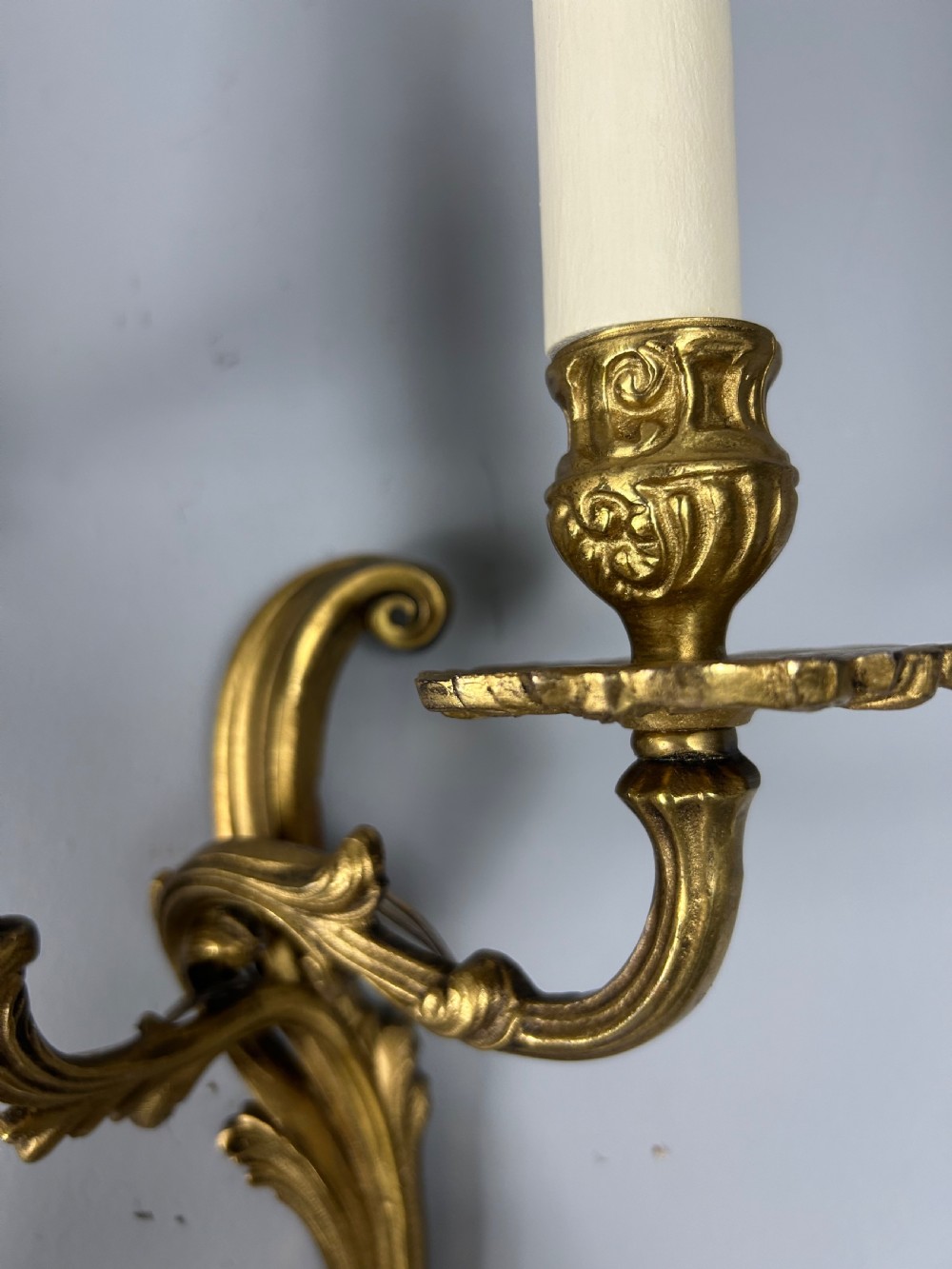 A set of four antique French twin-arm wall lights with a gilded finish and candle-style bulbs. View VIII