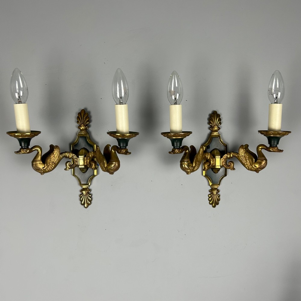 A pair of French Empire style double-arm gilt brass wall sconces featuring sculpted swan-neck branches and central palmette backplates. View XI