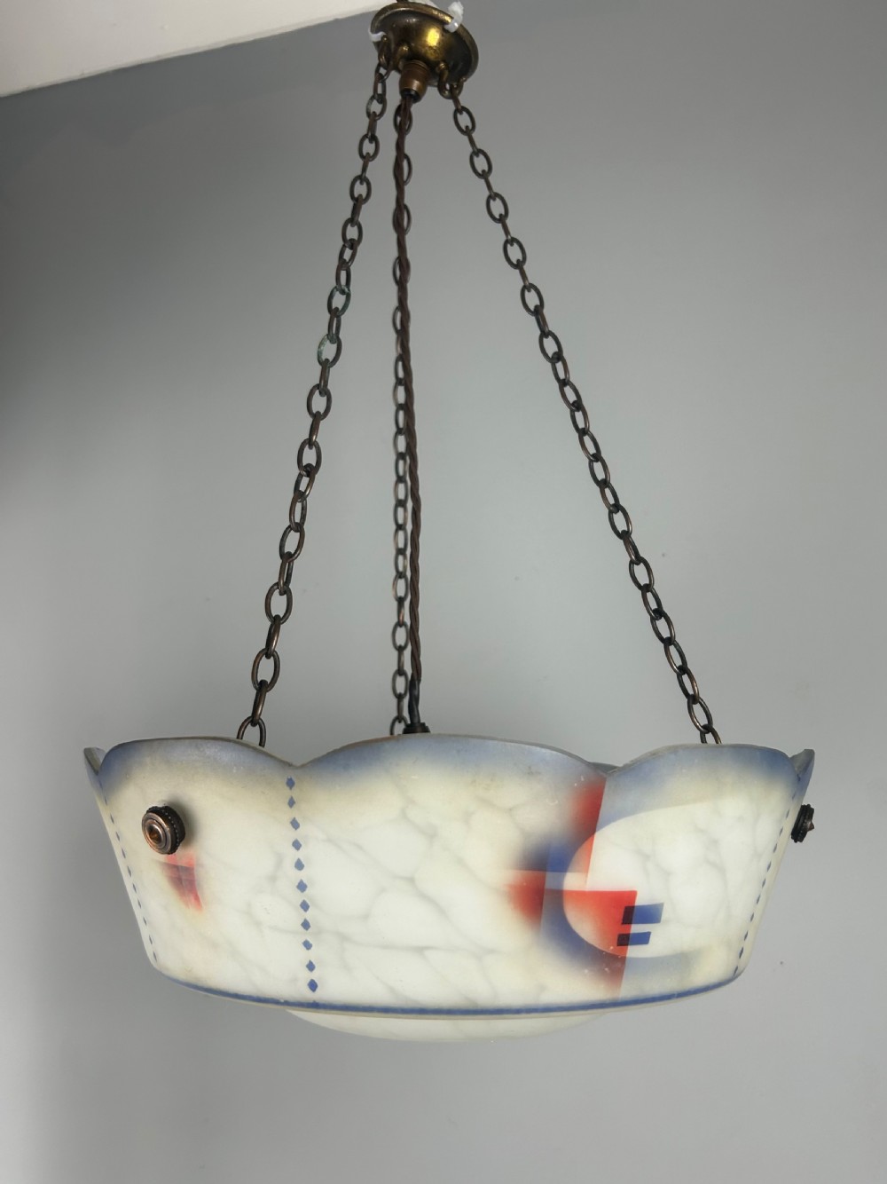 An Art Deco frosted glass plafonnier ceiling light shade with painted blue and orange geometric patterns suspended by brass chains. View VIII