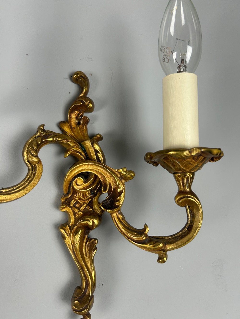 A pair of French Rococo style gilded bronze two-light wall sconces featuring acanthus leaf scrolls and candle-effect sleeves. View VII