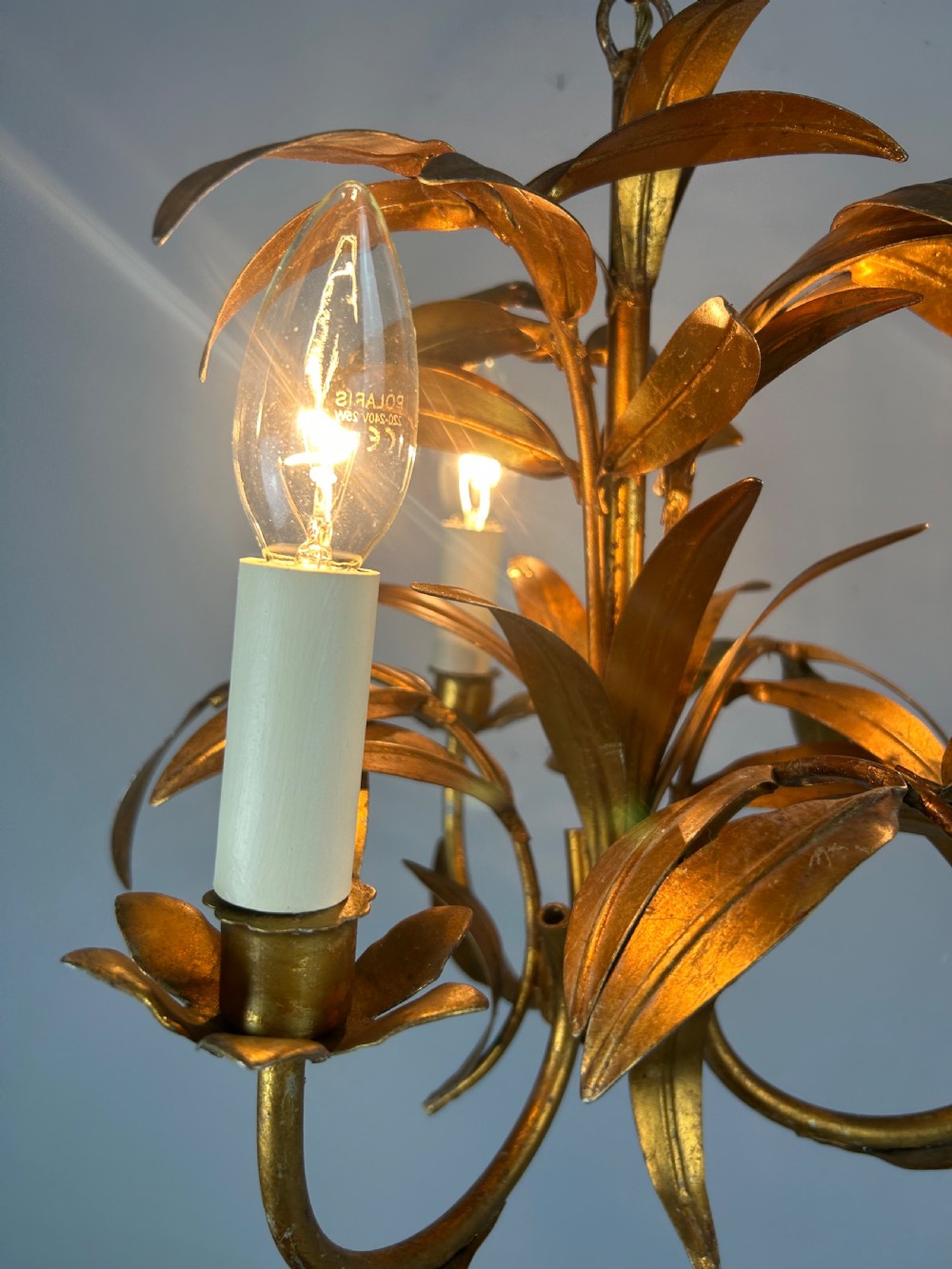 A French gilt metal three-light chandelier featuring curved arms and hand-shaped botanical leaf decoration. View II