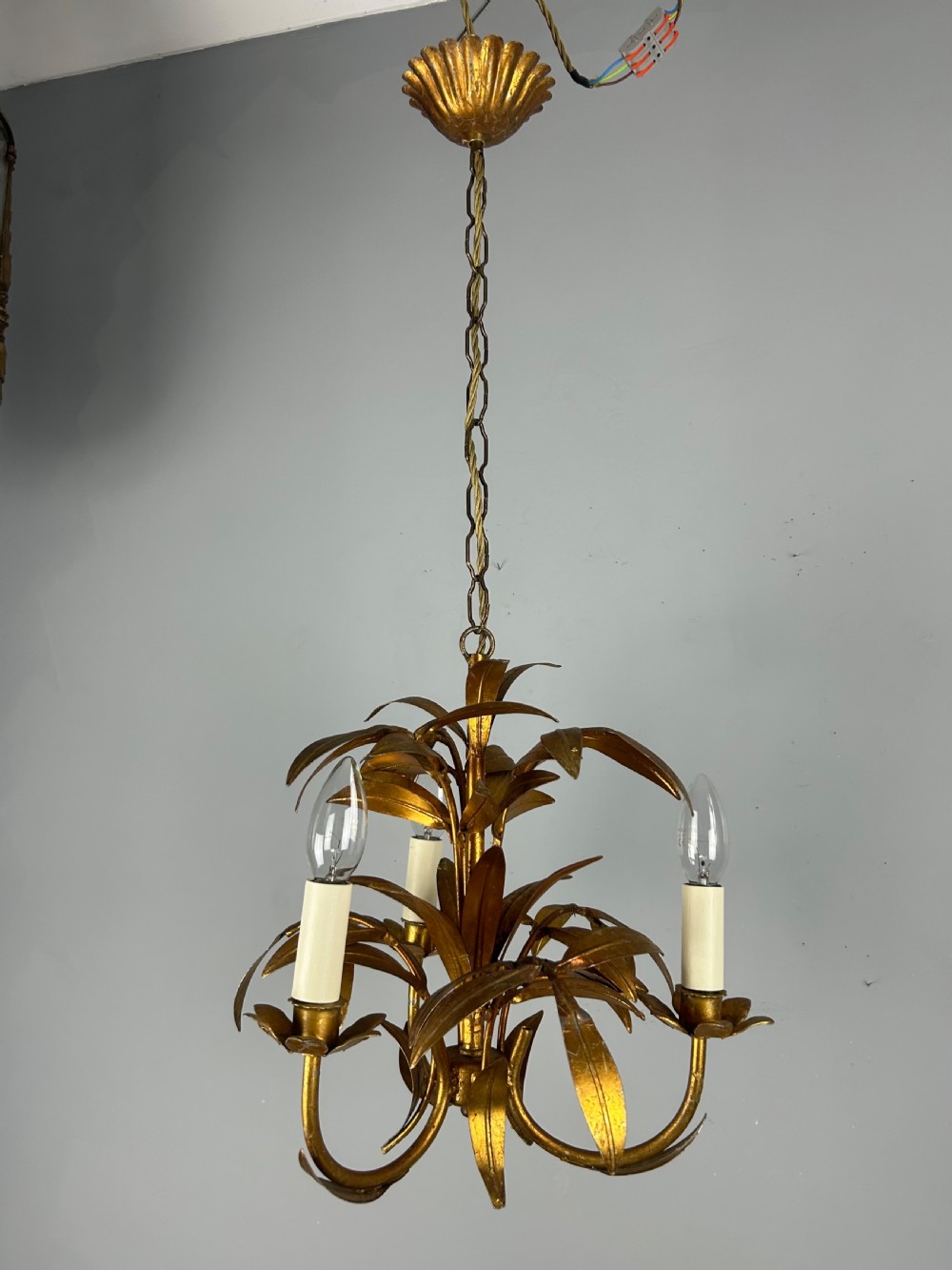A French gilt metal three-light chandelier featuring curved arms and hand-shaped botanical leaf decoration. View VI