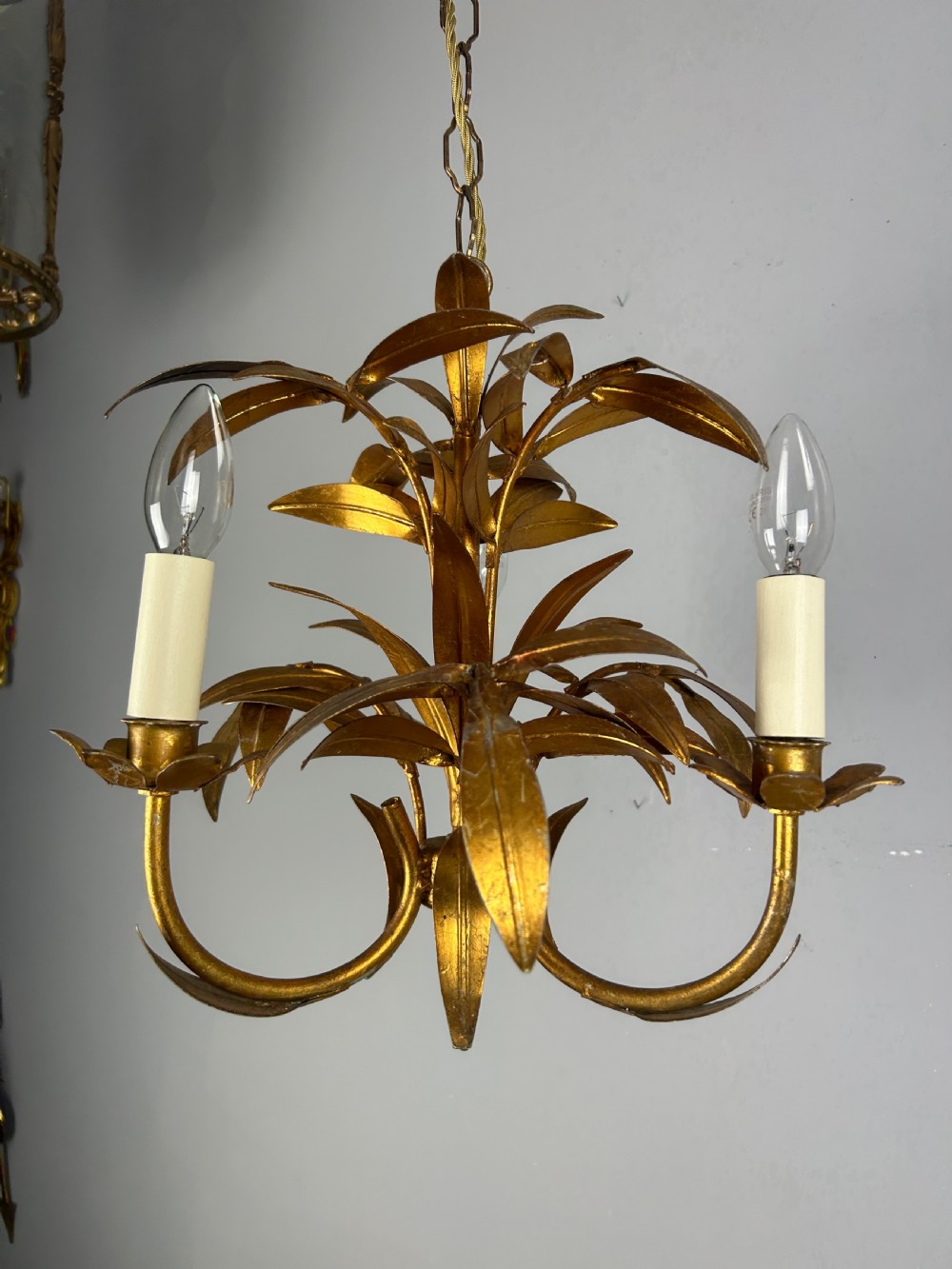 A French gilt metal three-light chandelier featuring curved arms and hand-shaped botanical leaf decoration. View VIII