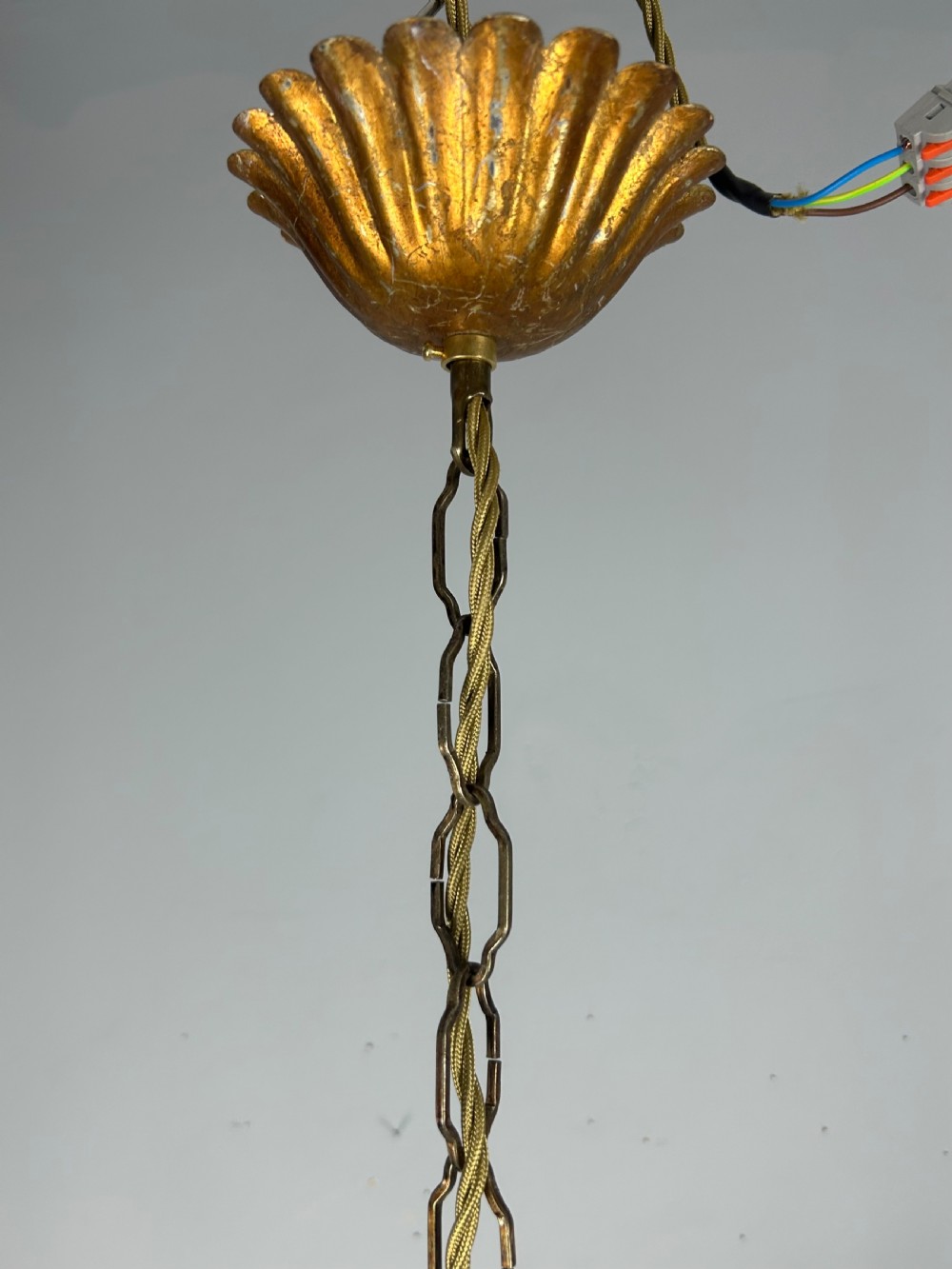 A French gilt metal three-light chandelier featuring curved arms and hand-shaped botanical leaf decoration. View IX