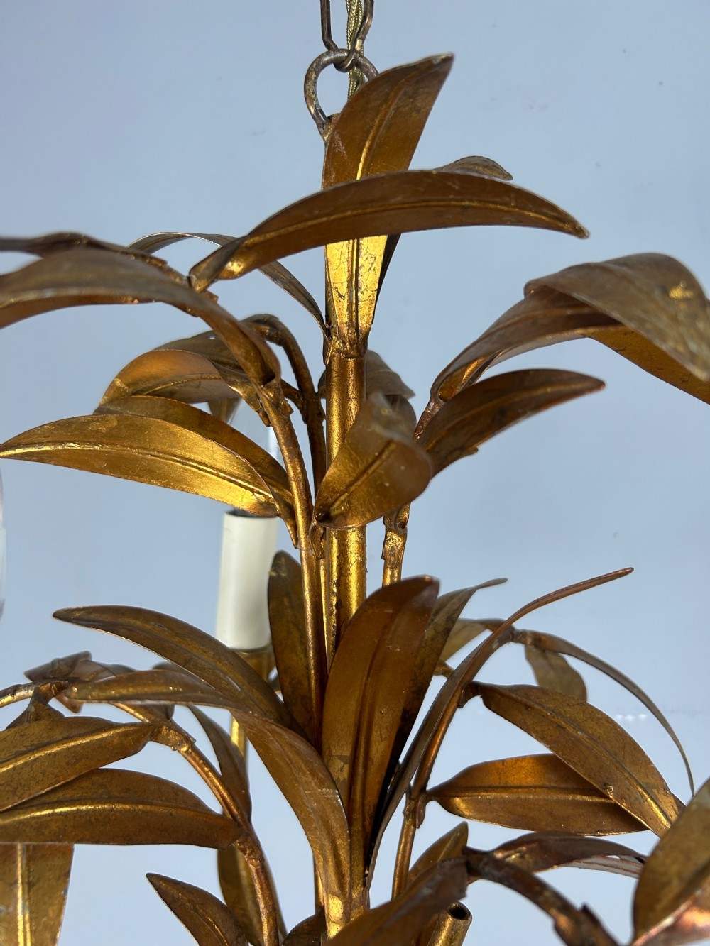 A French gilt metal three-light chandelier featuring curved arms and hand-shaped botanical leaf decoration. View X