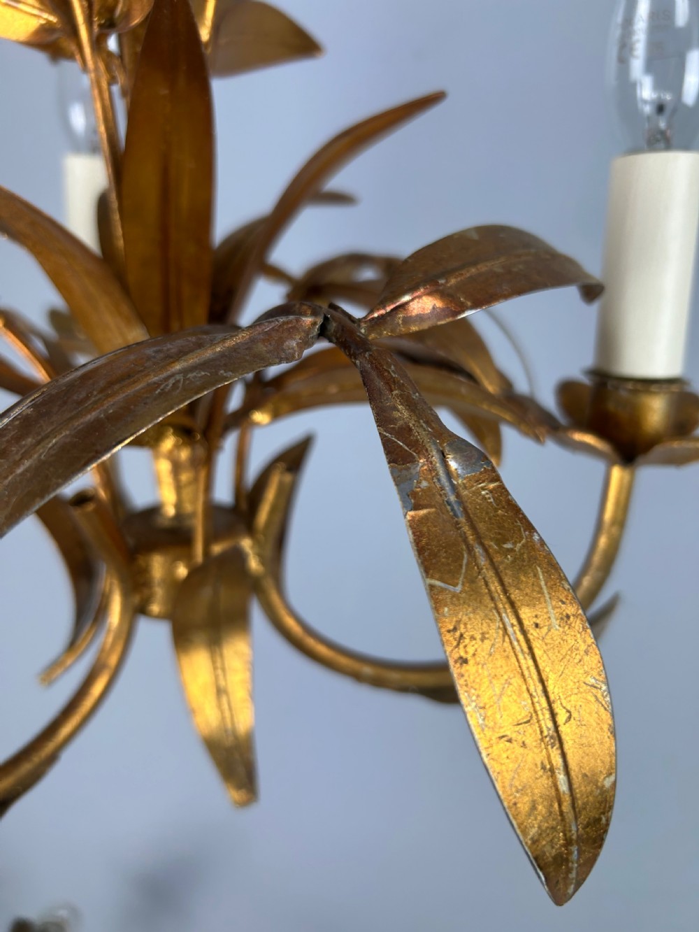 A French gilt metal three-light chandelier featuring curved arms and hand-shaped botanical leaf decoration. View XI