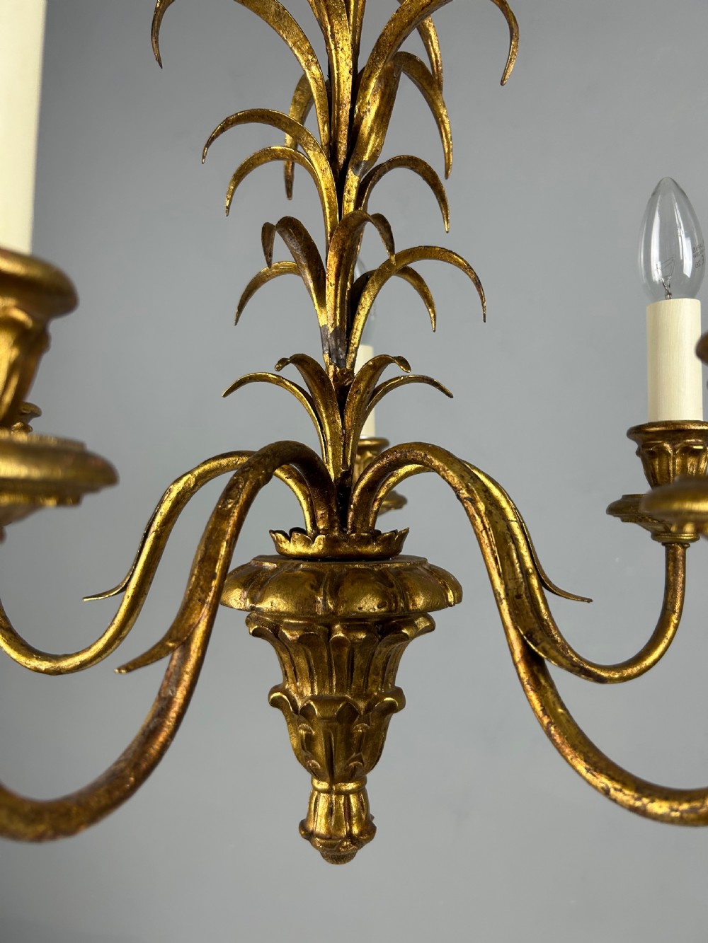 A five-light French gilt metal chandelier featuring curved branches, central leaf foliage design, and cream candle sleeves. View III