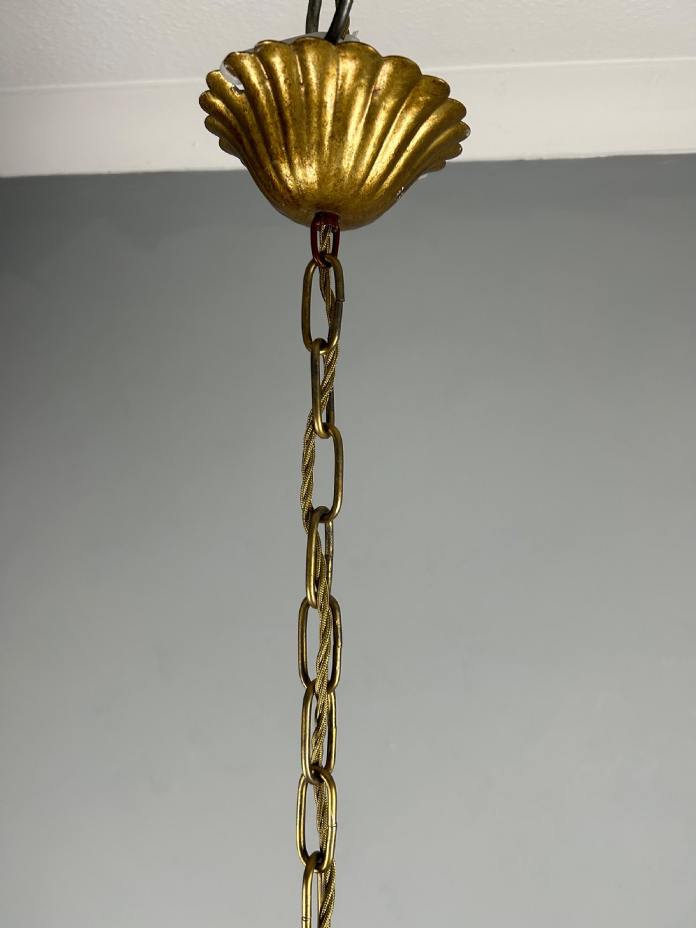 A five-light French gilt metal chandelier featuring curved branches, central leaf foliage design, and cream candle sleeves. View VI