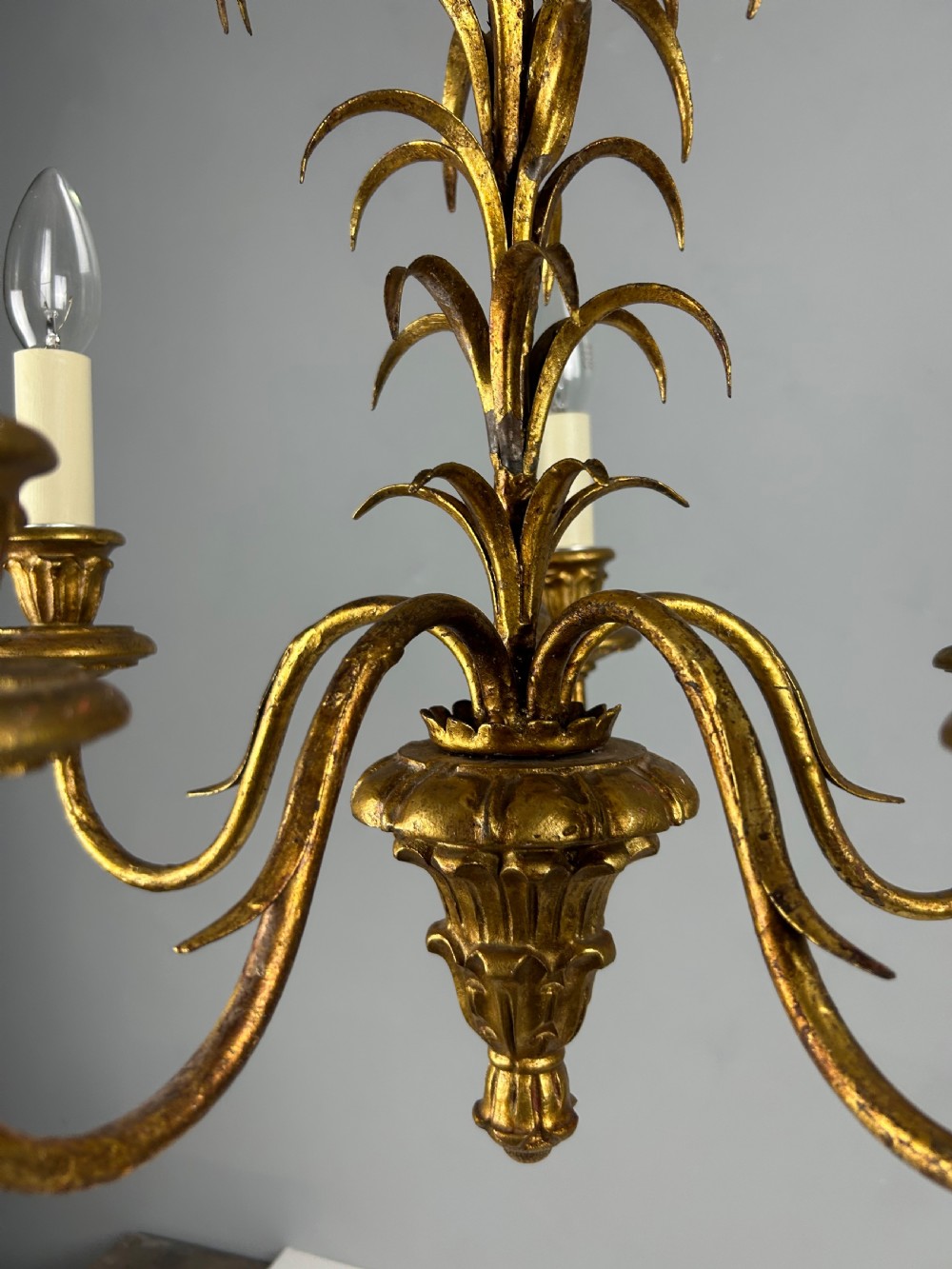 A five-light French gilt metal chandelier featuring curved branches, central leaf foliage design, and cream candle sleeves. View VIII