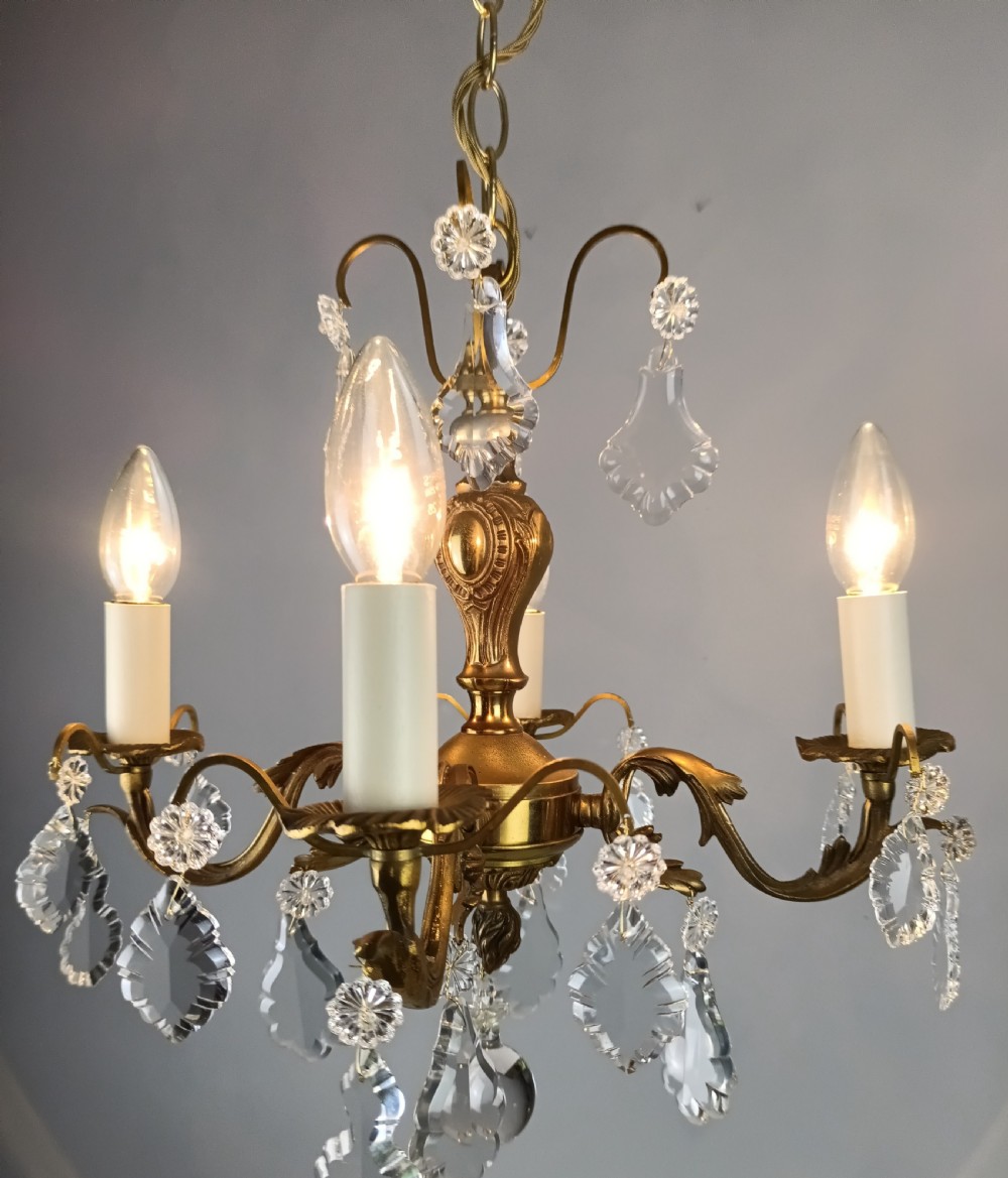 A French gilded brass four-light chandelier adorned with faceted crystal drops and a central crystal sphere finial. View III