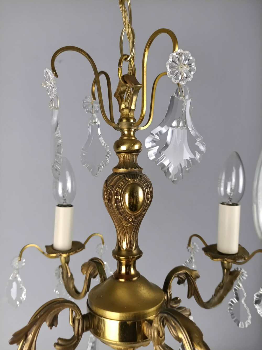 A French gilded brass four-light chandelier adorned with faceted crystal drops and a central crystal sphere finial. View X