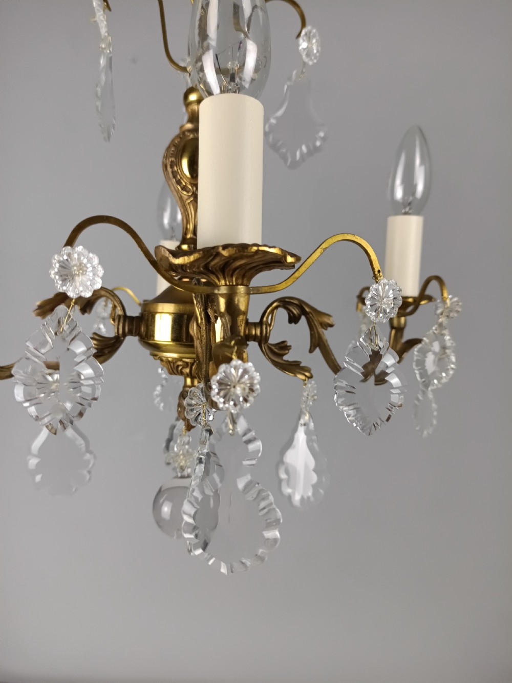 A French gilded brass four-light chandelier adorned with faceted crystal drops and a central crystal sphere finial. View XI