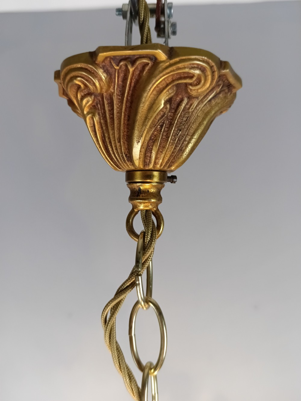 A three-arm French gilt brass chandelier decorated with scrolling foliate branches, candle sleeves, and faceted crystal glass drops. View VII