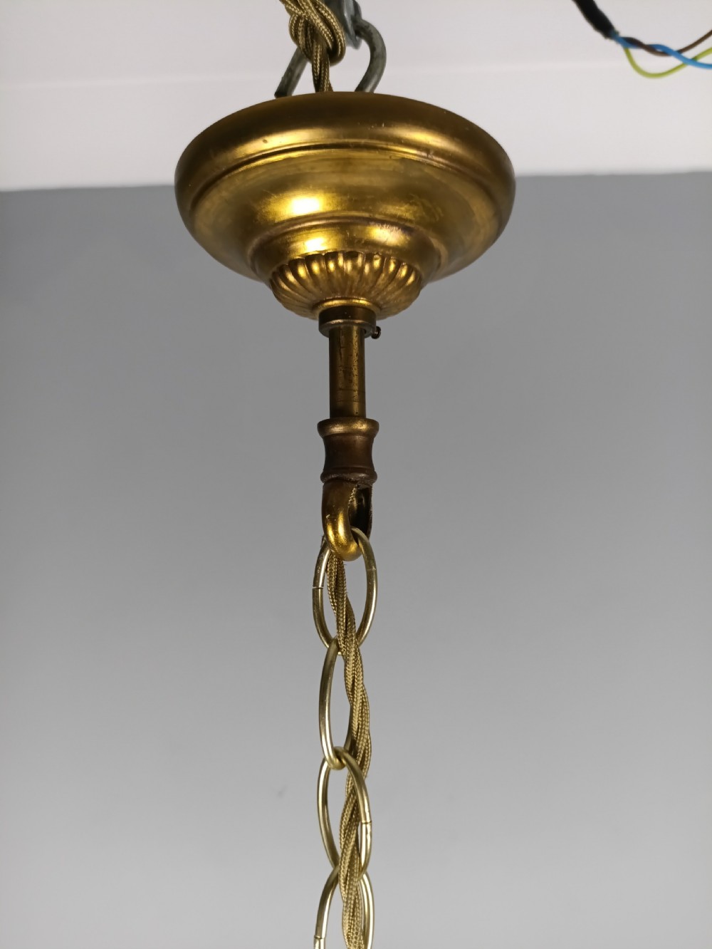 A four-light French gilded brass chandelier featuring a central glass column and hanging cut crystal drops. View VII