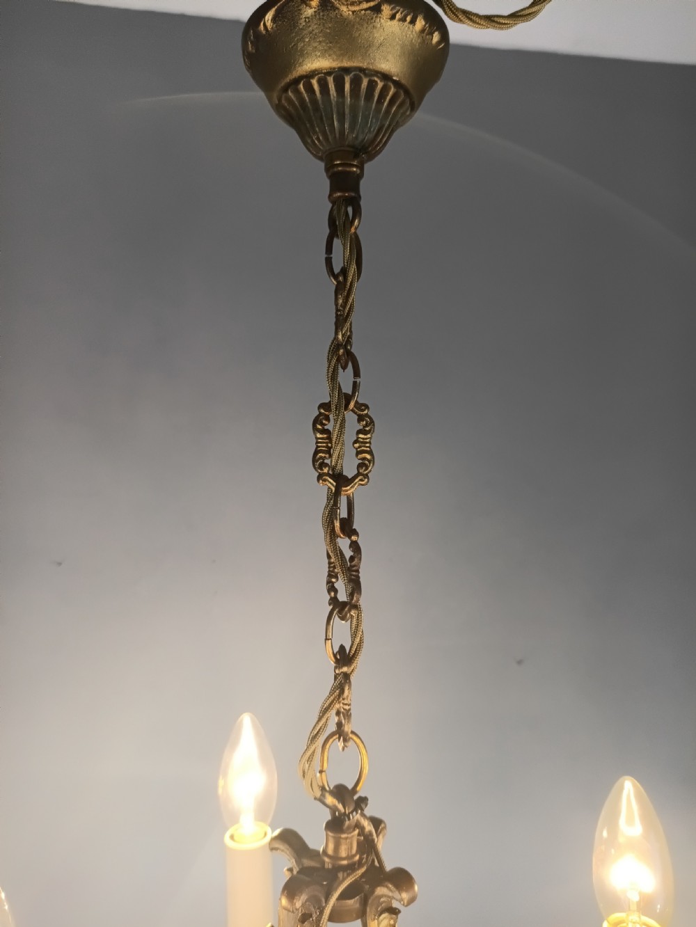 A four-arm French gilded brass chandelier adorned with cut crystal drops and cream candle-effect light holders. View IV