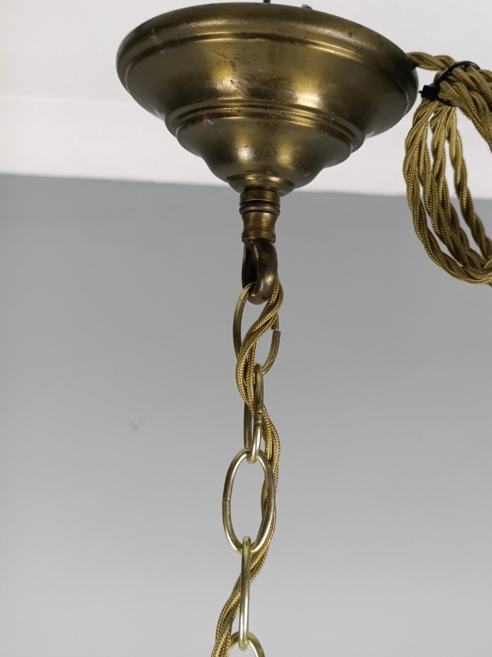 A French style gilt brass six arm chandelier embellished with clear glass stem sections and suspended crystal teardrop prisms. View III