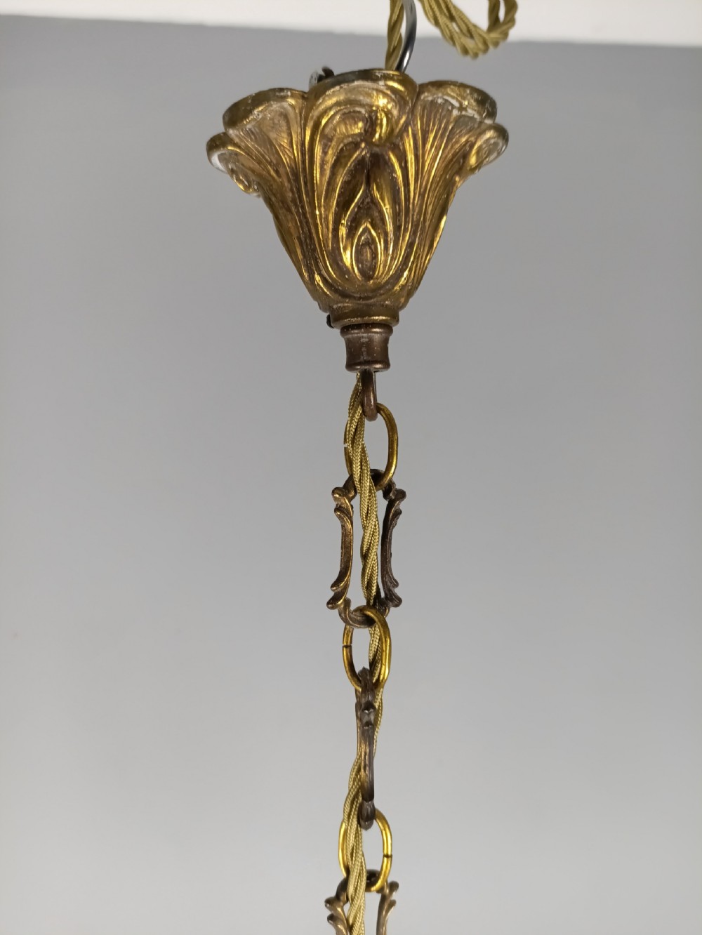 A French six-arm gilded metal chandelier featuring scrolling foliage arms, candle-style bulb holders, and hanging clear cut crystal droplets. View VII