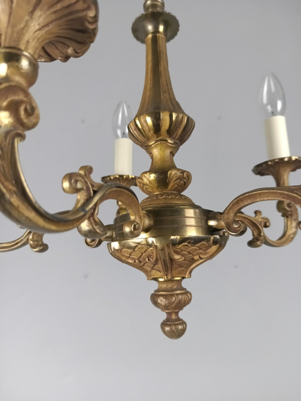 A French gilt brass five-arm chandelier featuring scrolling branch arms, candle bulb sleeves, and an ornate central column. View II