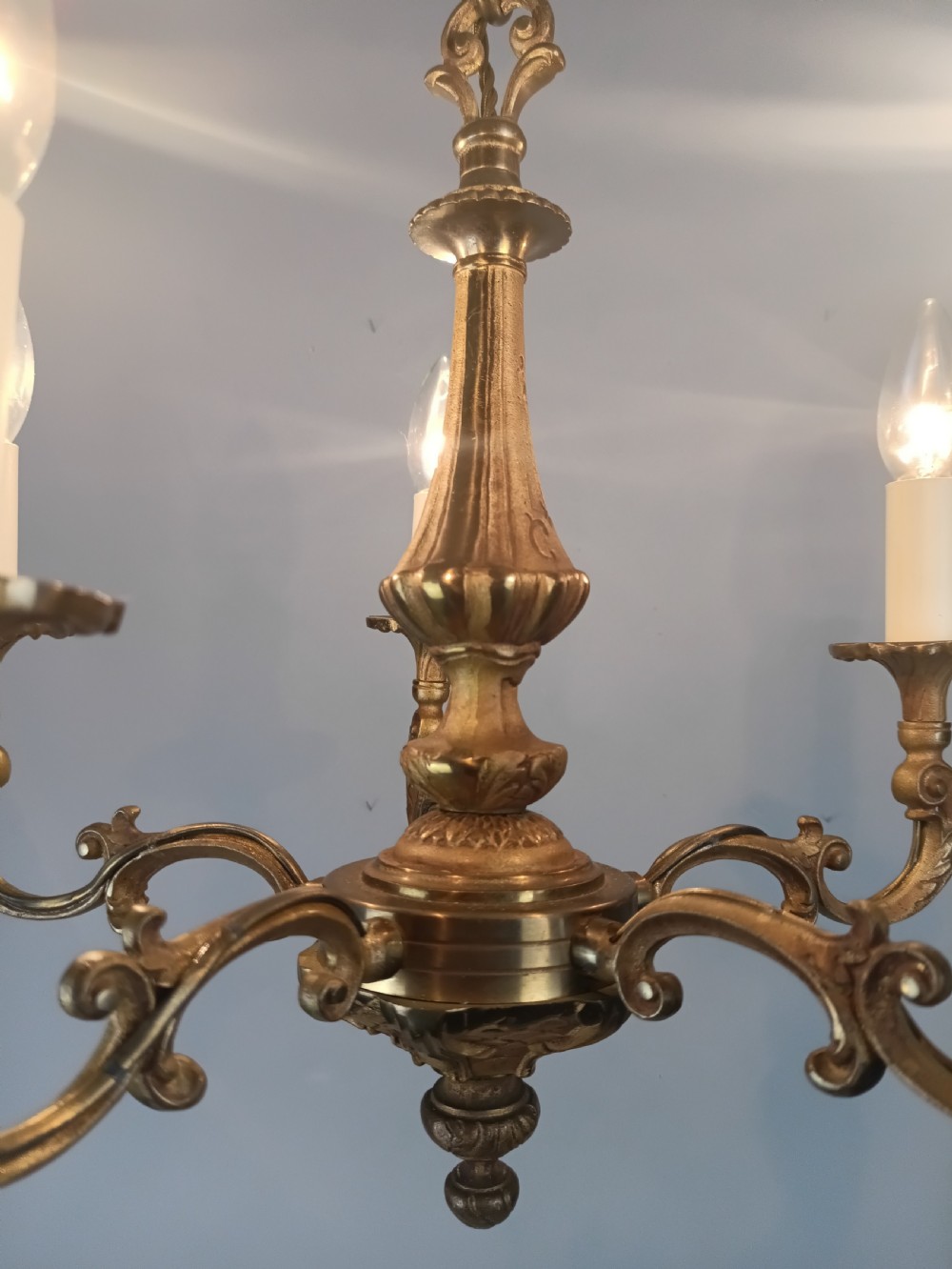 A French gilt brass five-arm chandelier featuring scrolling branch arms, candle bulb sleeves, and an ornate central column. View III